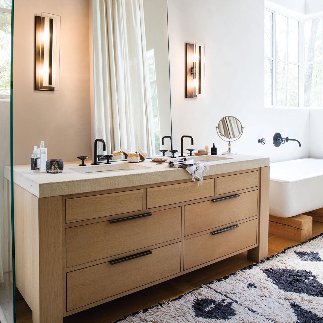 bathroom with lighting sconces on each side of vanity mirror